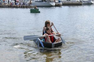 Rowan McCann and Finn Sweeney row their way to victory in the open race at the carboard boat regatta.