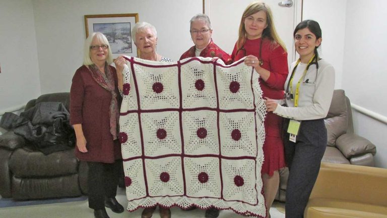 Hospital auxiliary donates handmade bedspread to palliative care